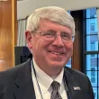 A smiling man wearing a suit jacket at an event